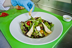 Выложенный на тарелку салат украсить артишоками.