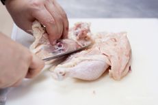 Разрезаем курицу пополам и из рабочей половины уда...