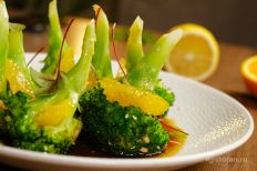 Выложите брокколи с орехами и кунжутом на тарелку,...